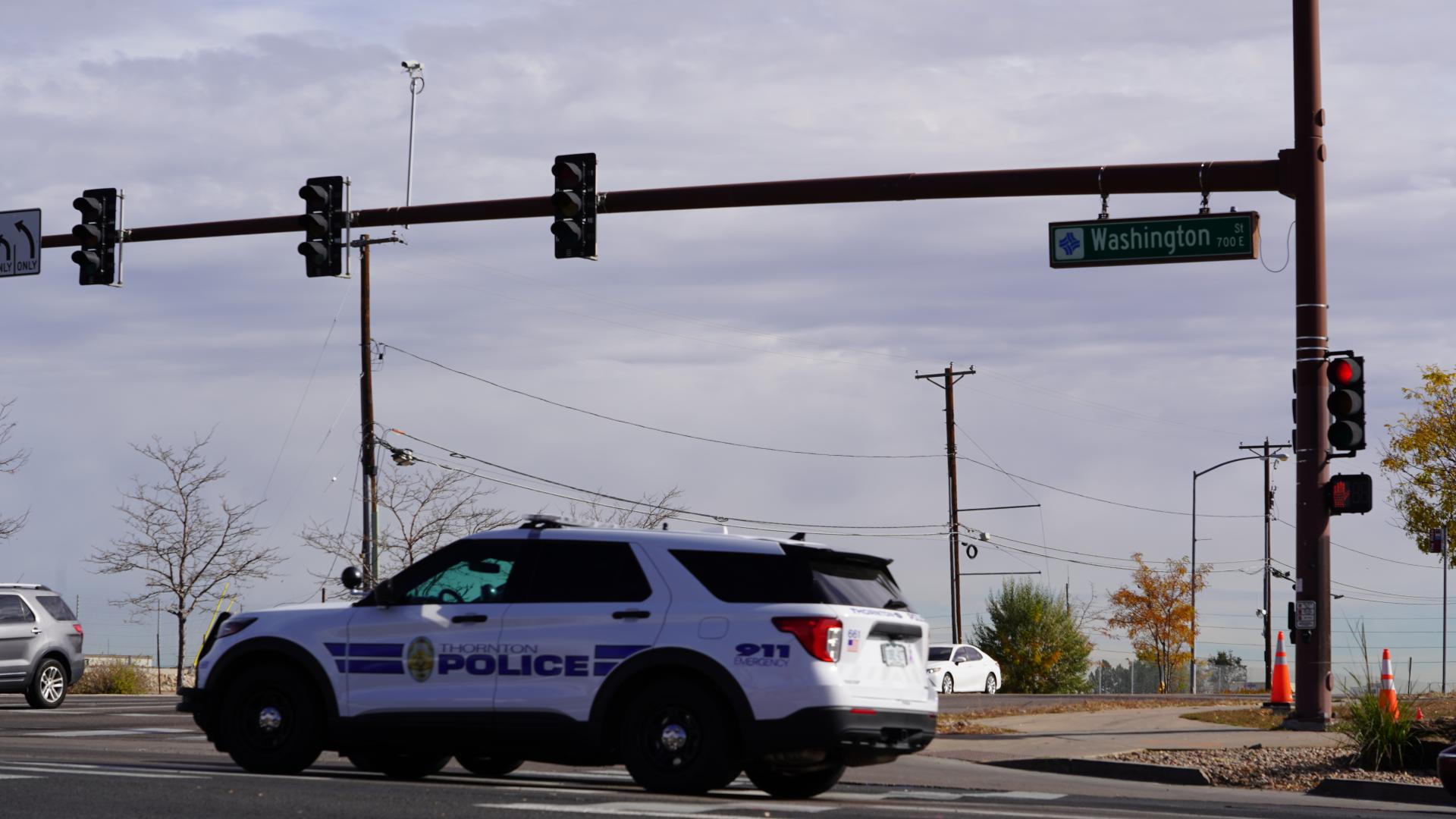 Patrol car driving through intersection with traffic lights and cameras
