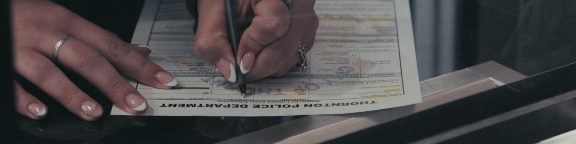 Hands writing on police records form