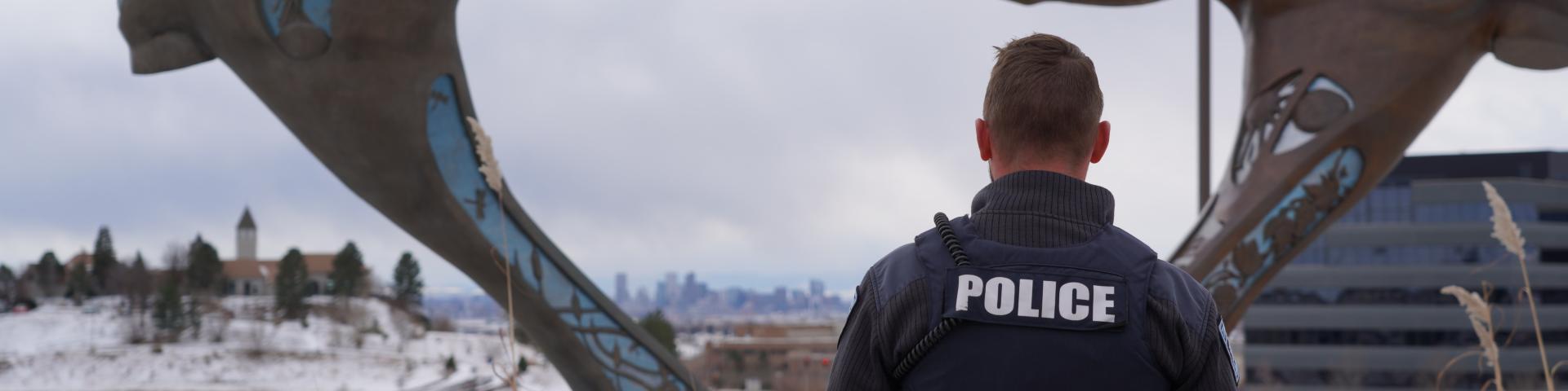 Police officer looking at the Denver skyline