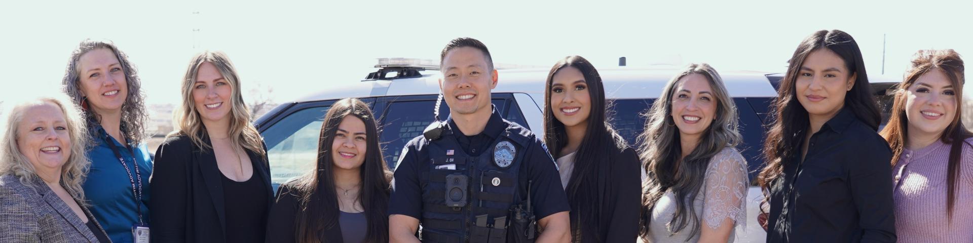 Victim advocates and police officer smiling at camera