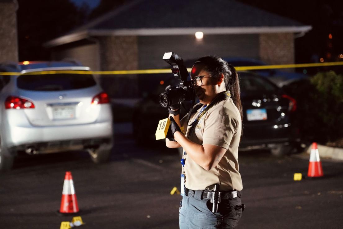 Criminalist taking photos at crime scene