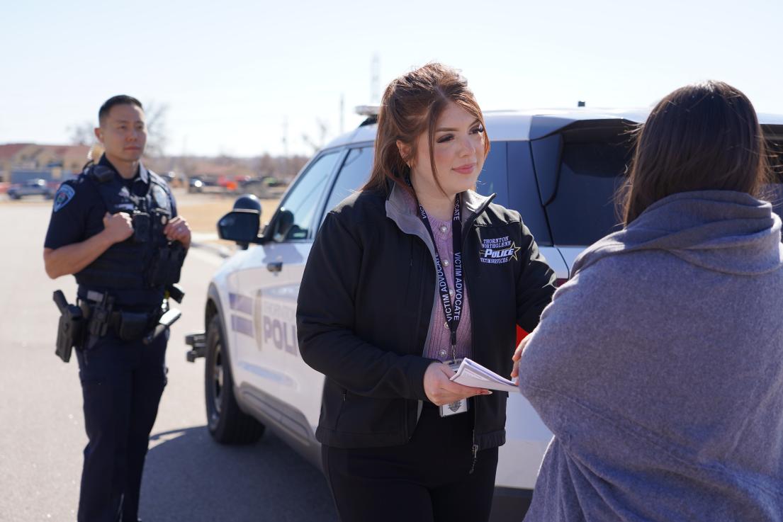 Victim advocate and police officer speaking with resident