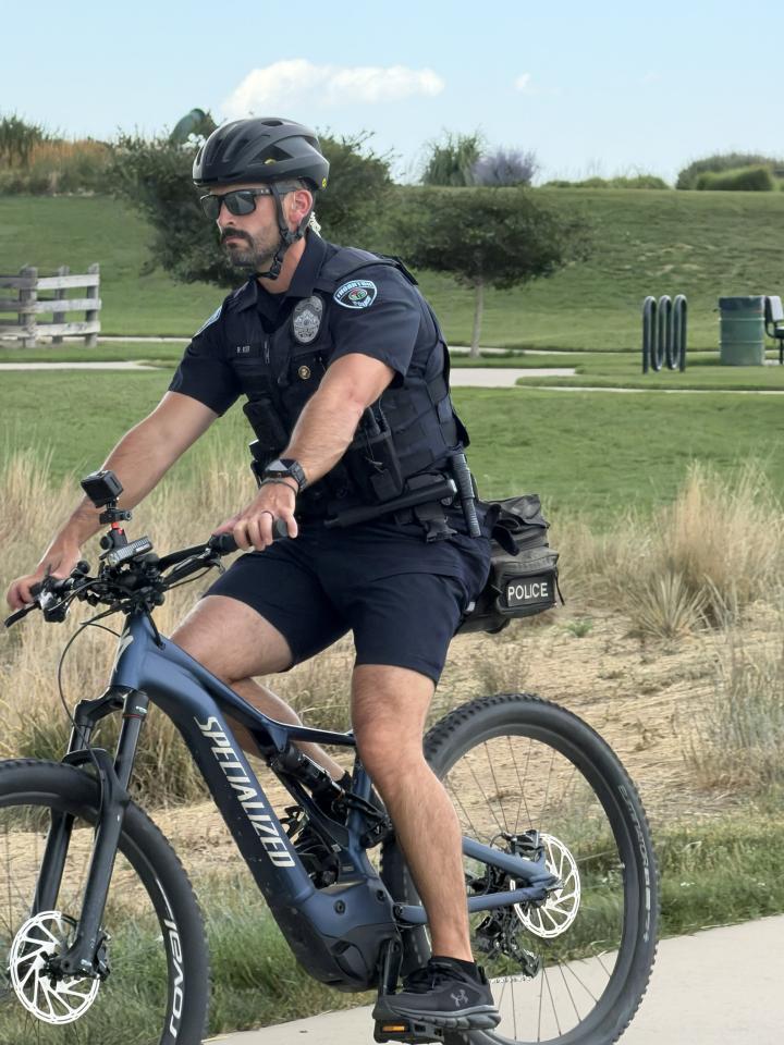 School resource officer on e-bike patrolling the park